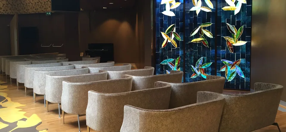 Aula van Hofwijk met zitplaatsen en een glas-in-loodwand